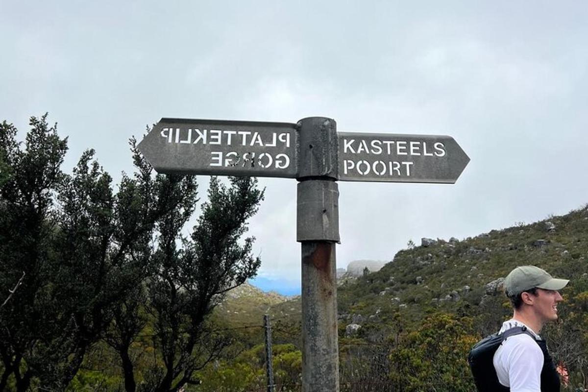 moški stoji poleg uličnega znaka