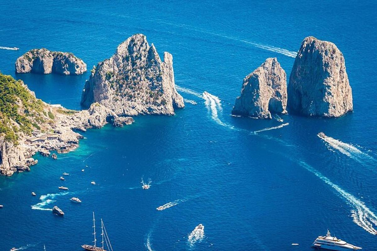 Un grupo de rocas en el océano con barcos.