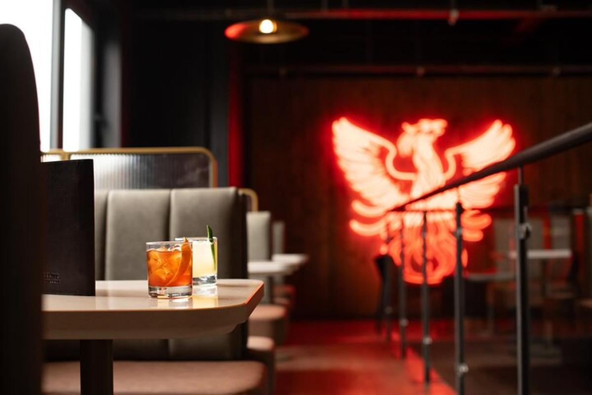 a drink sitting on a table in a room with a fireburning