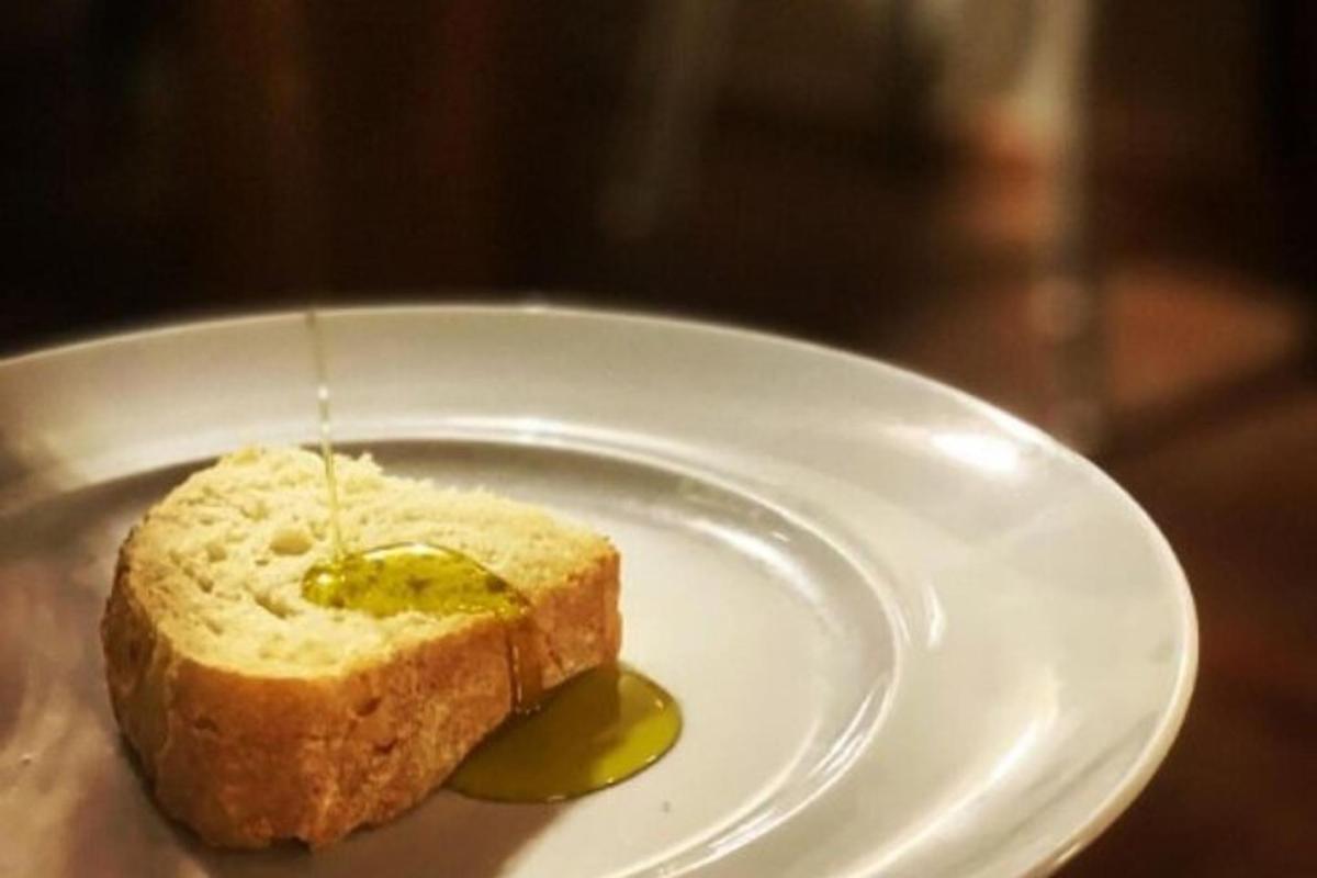 ένα άσπρο πιάτο με ένα κομμάτι ψωμί και ένα τουρσί