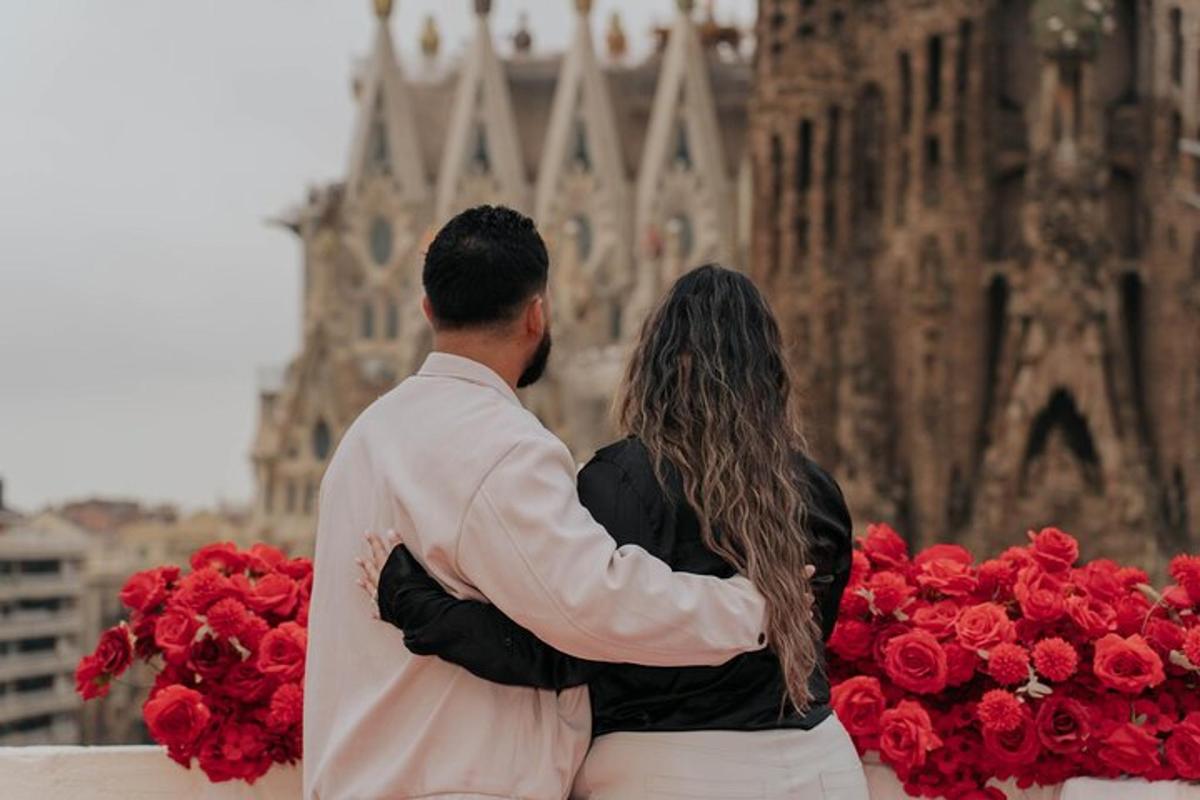 a man and woman sitting next to a pile of red roses