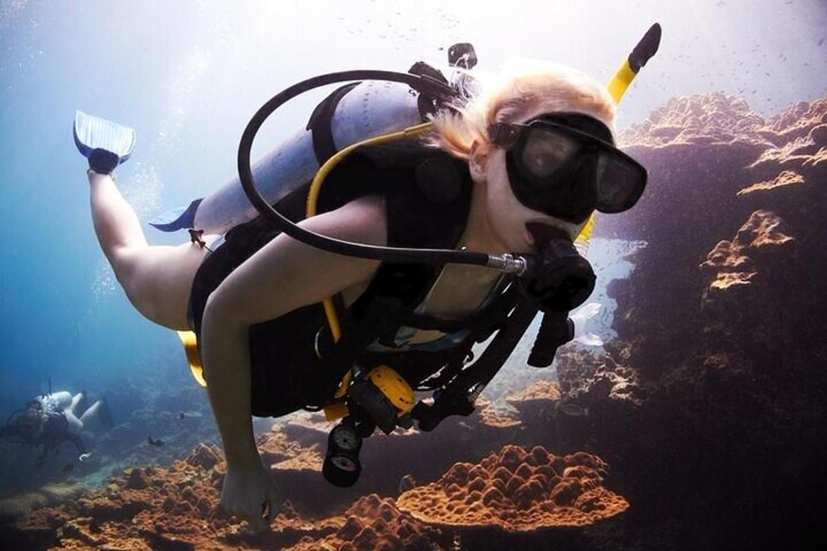 žena v potápěčském obleku a brýlích plave v oceánu