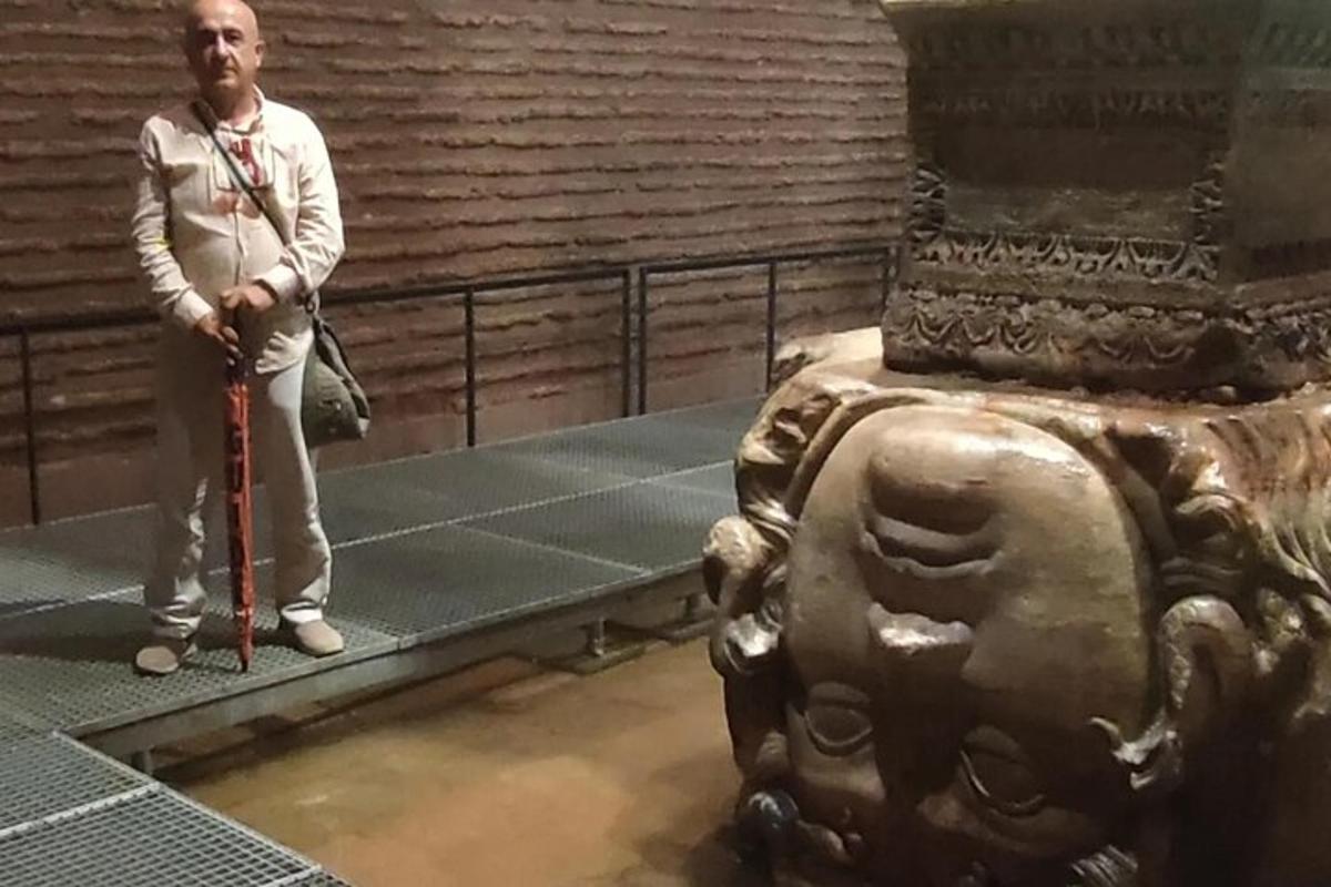 un uomo in piedi accanto a una statua in un museo