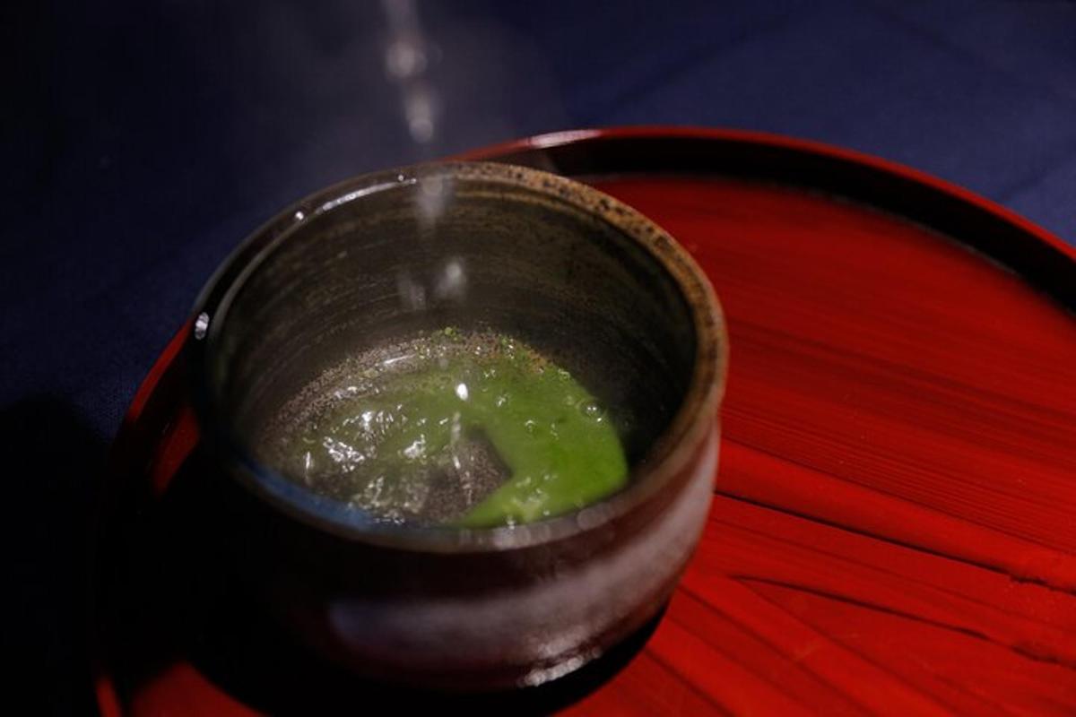 Un recipiente con líquido verde sobre una mesa roja.