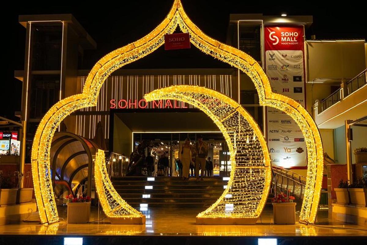 Un gran arco de metal frente a un centro comercial.