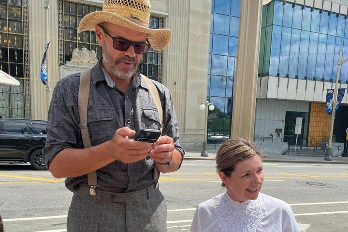un home amb un barret de cowboy mirant el seu telèfon mòbil