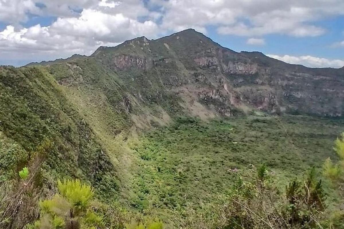 una vista d'una muntanya amb un camp verd