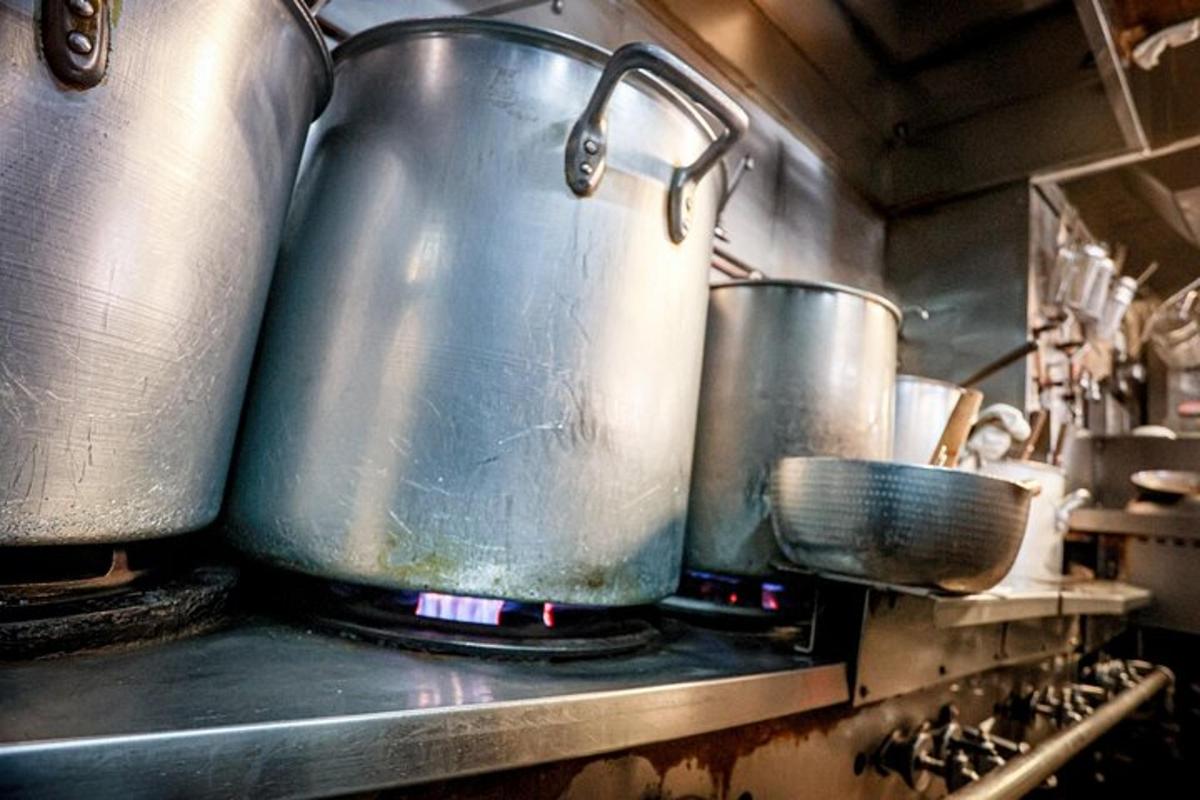 two large pots and pans on a stove in a kitchen