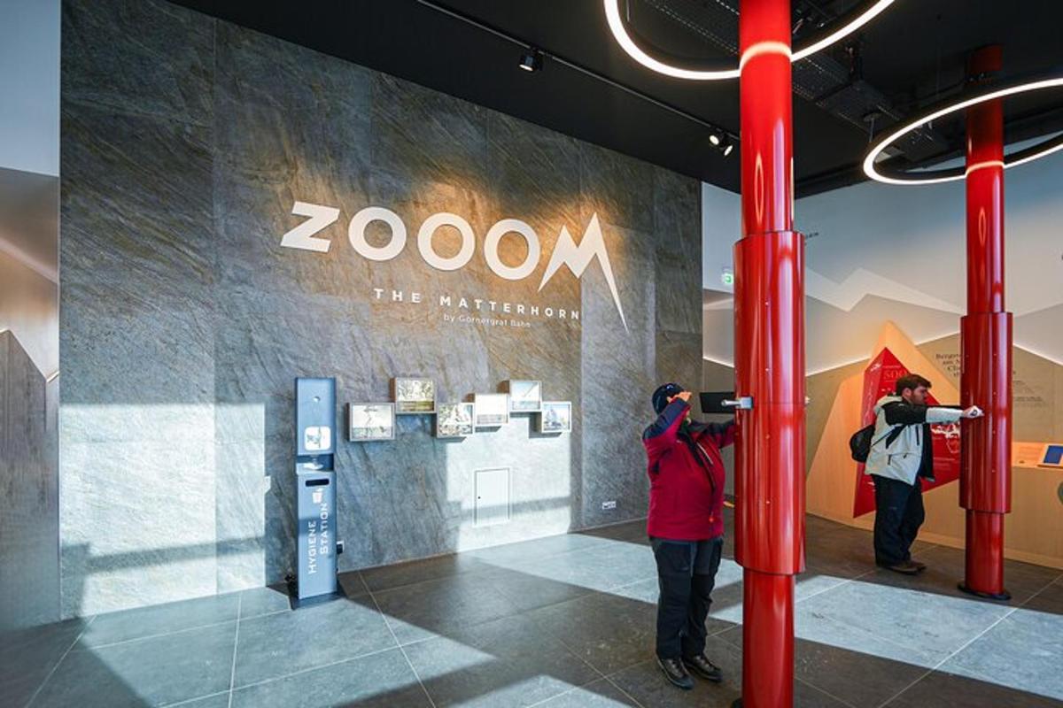 two people taking pictures of a zoom sign in a building
