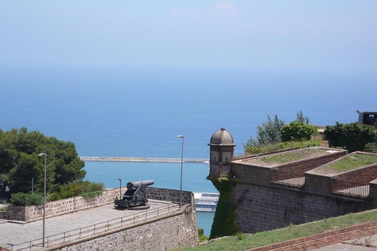 a cannon sitting on the side of a wall with the ocean