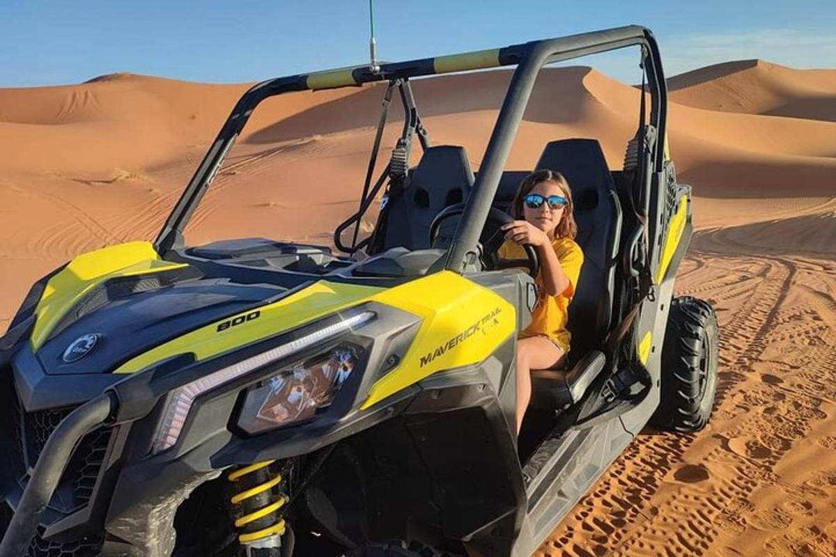 một người phụ nữ ngồi trong xe jeep ở sa mạc