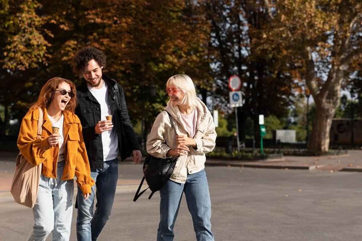 a man and two women walking down a street with cell phones