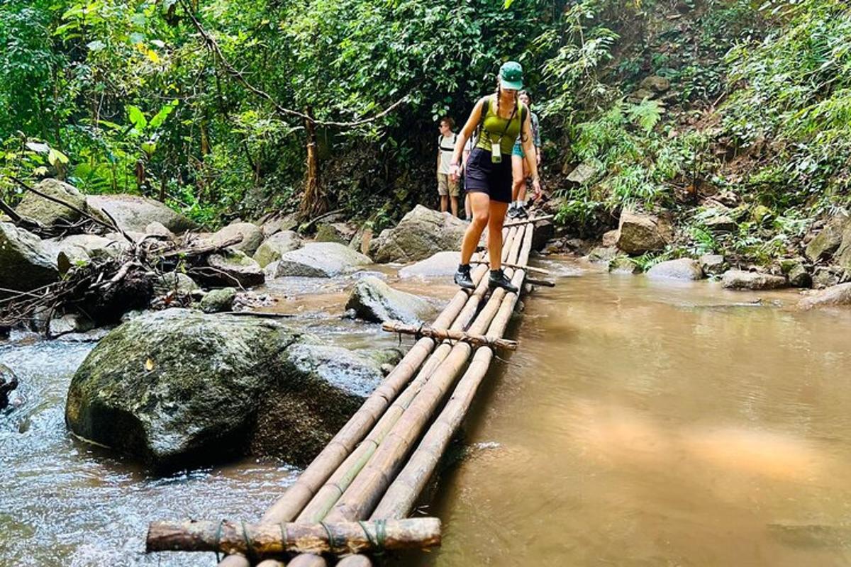 a person crossing a rope bridge over a river