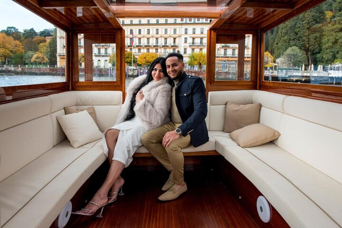 Una novia y un novio sentados en la parte trasera de un barco