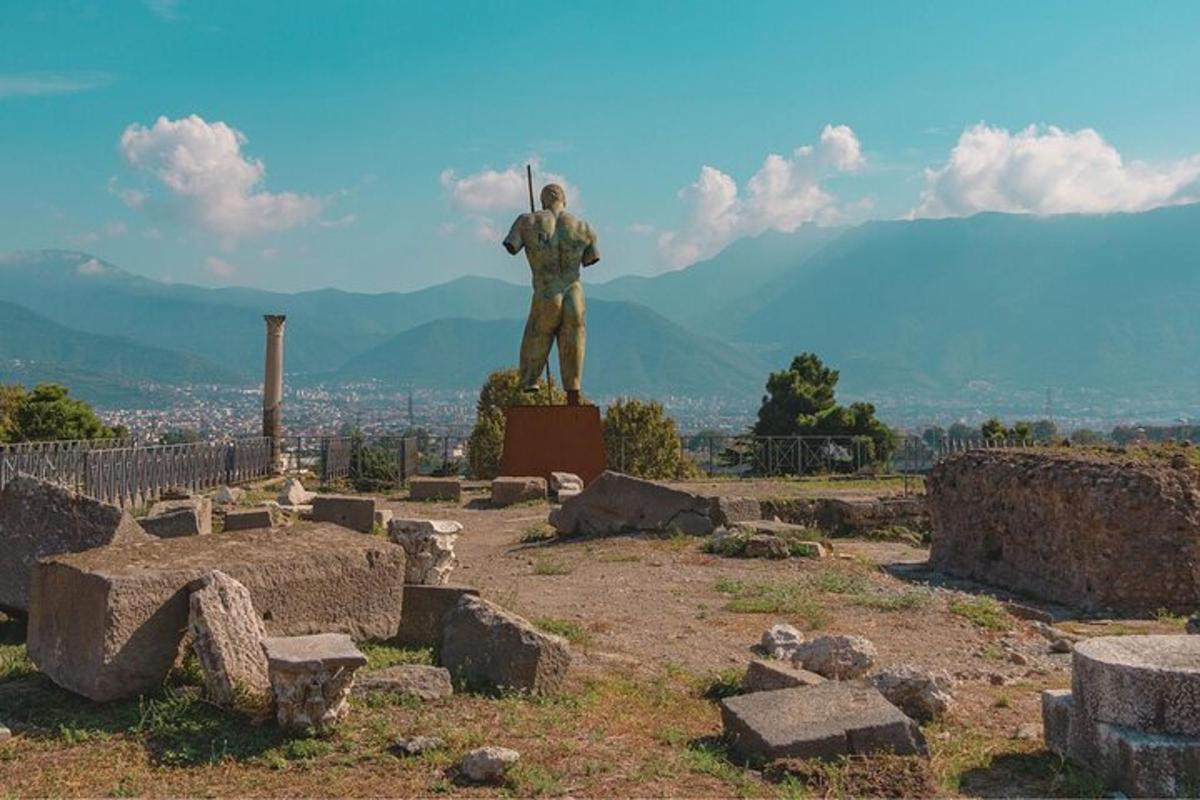 uma estátua de um homem em pé no topo de uma colina