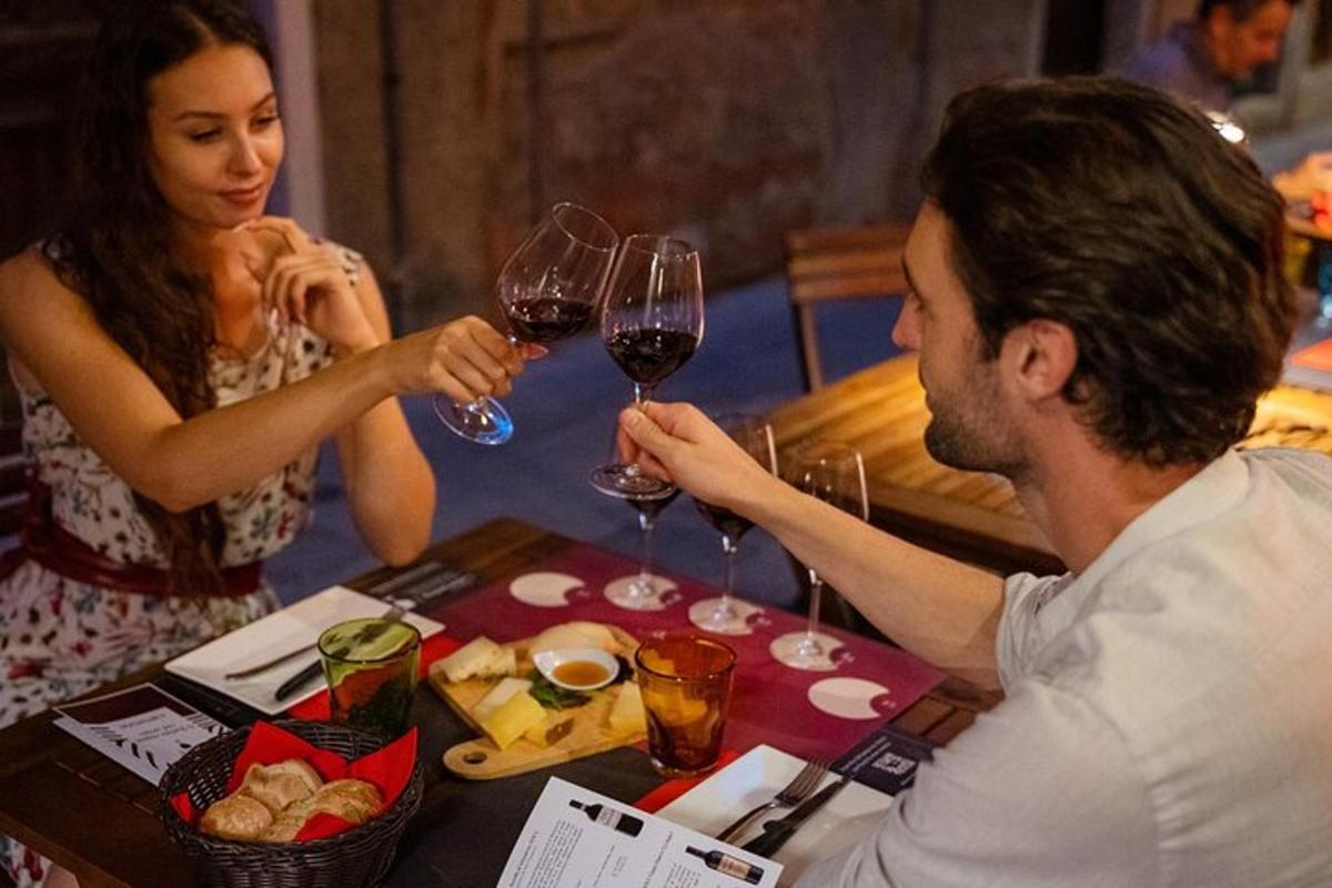 Un hombre y una mujer sentados en una mesa con copas de vino.