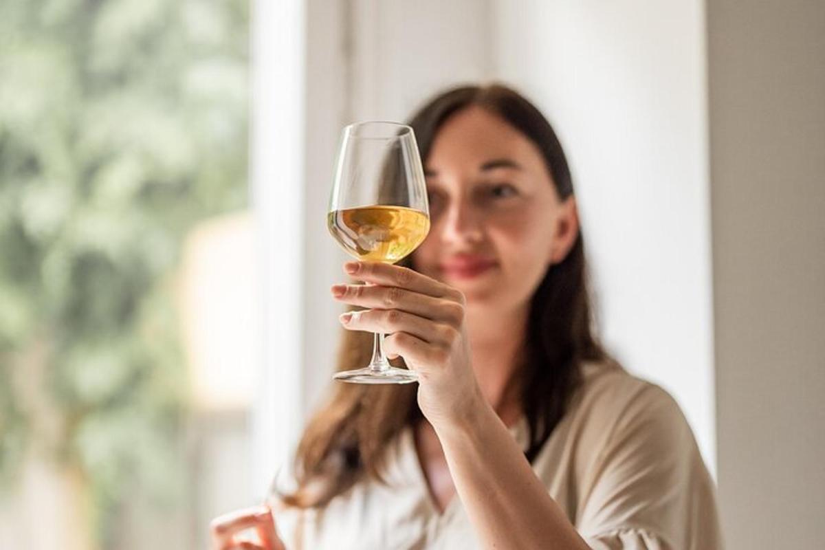 žena držící sklenici bílého vína