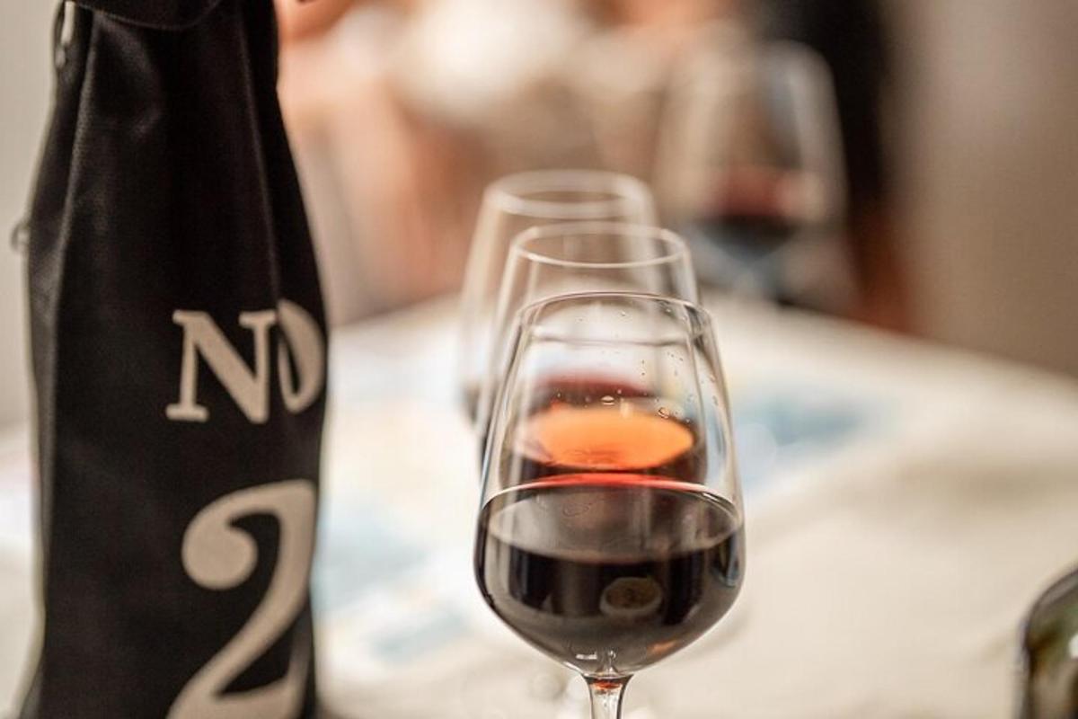 un bicchiere di vino rosso accanto a una borsa
