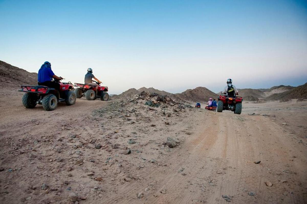 a group of people riding atvs on a dirt road