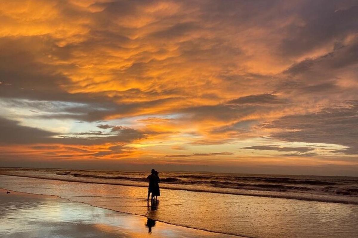 una persona parada en la playa al atardecer