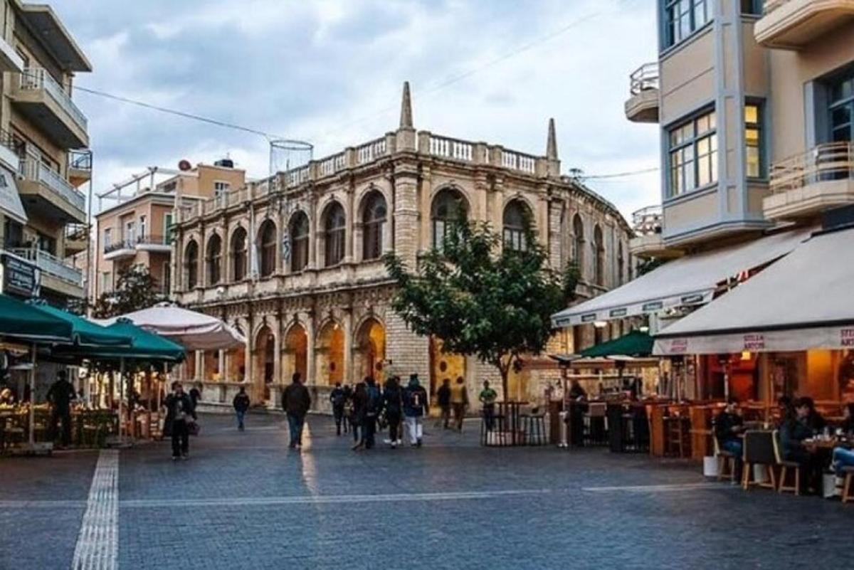 skupina lidí jdoucích po ulici před budovou
