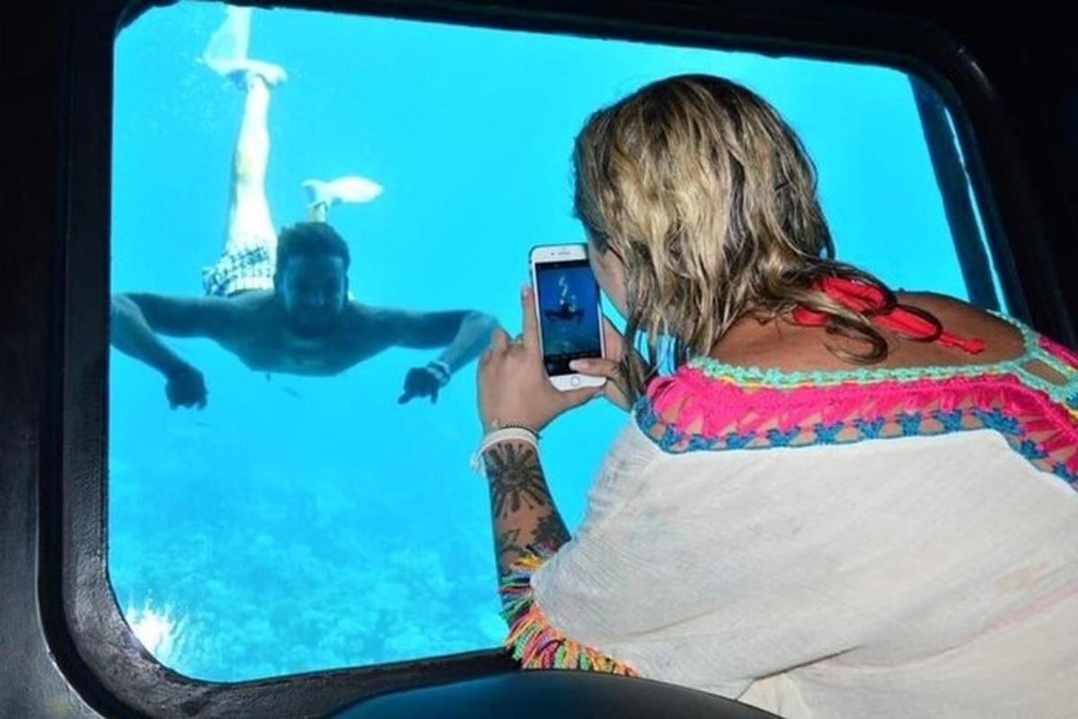 a woman taking a picture of a man in the water