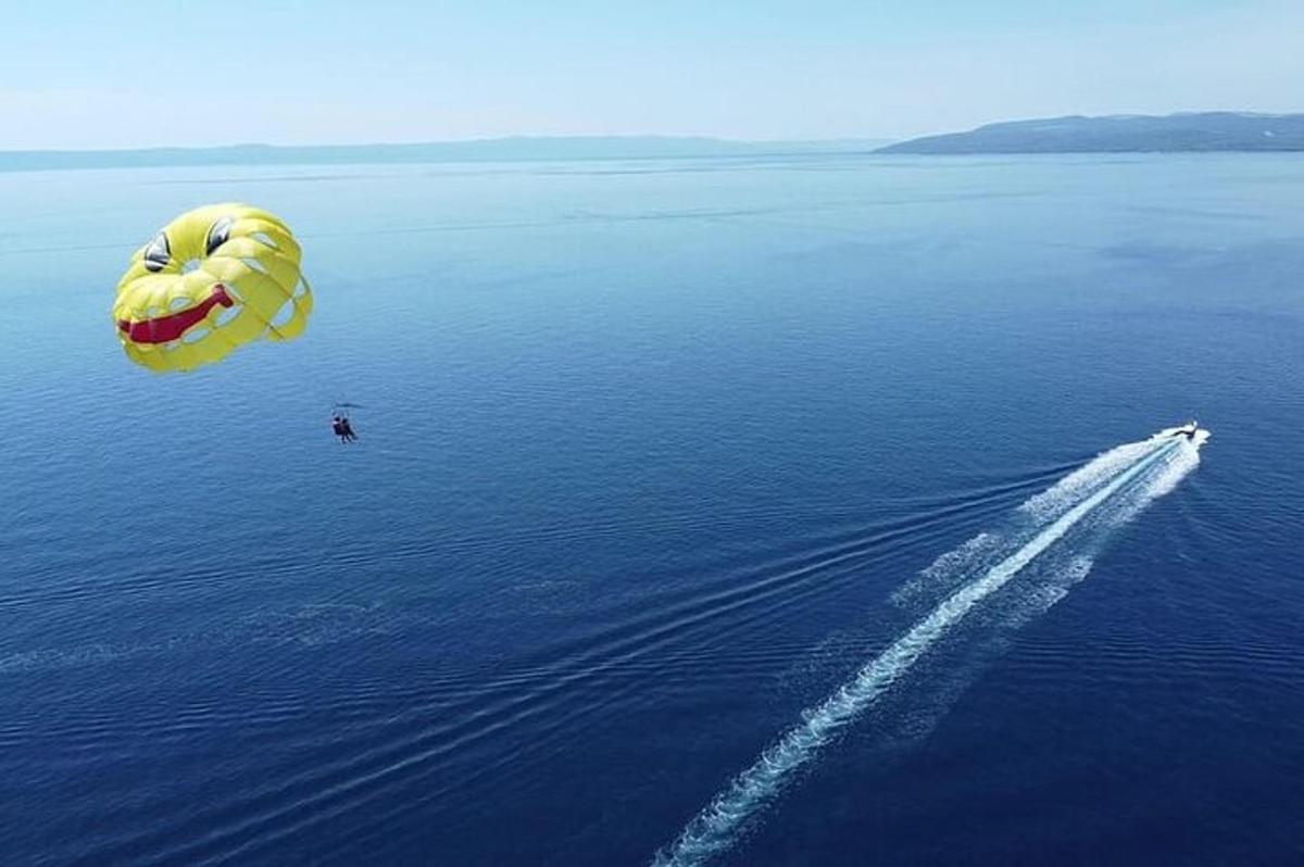 a person flying a parachute over the water with a boat