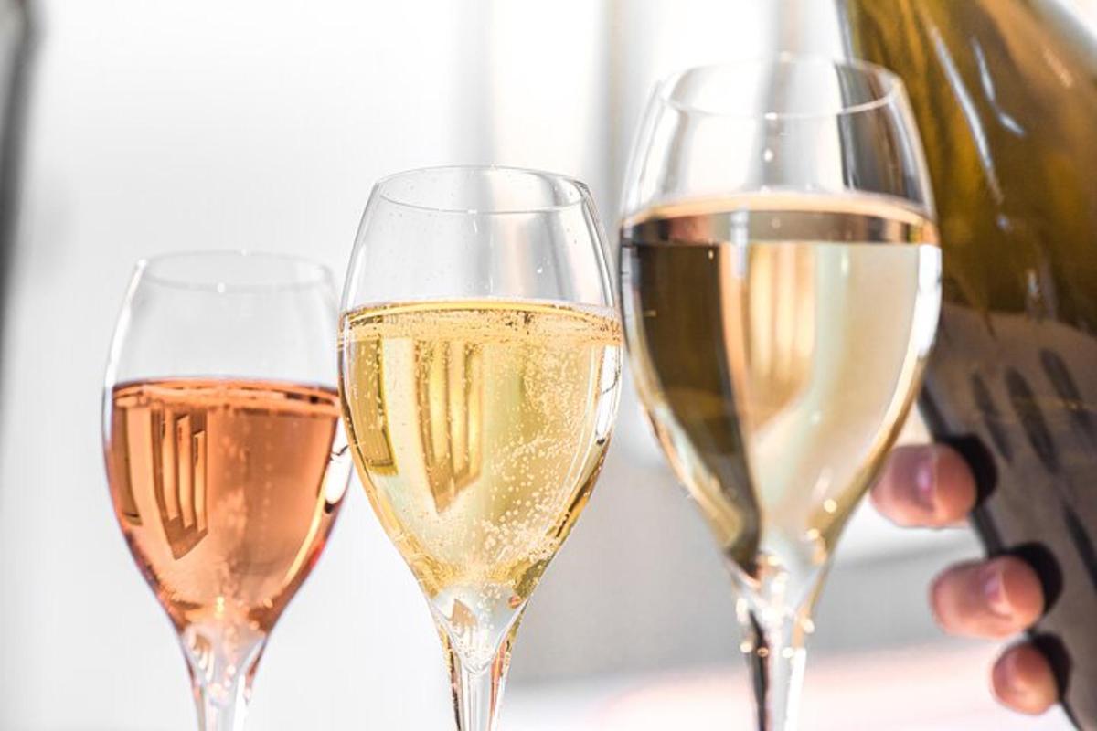duas taças de champanhe ao lado de uma garrafa de vinho