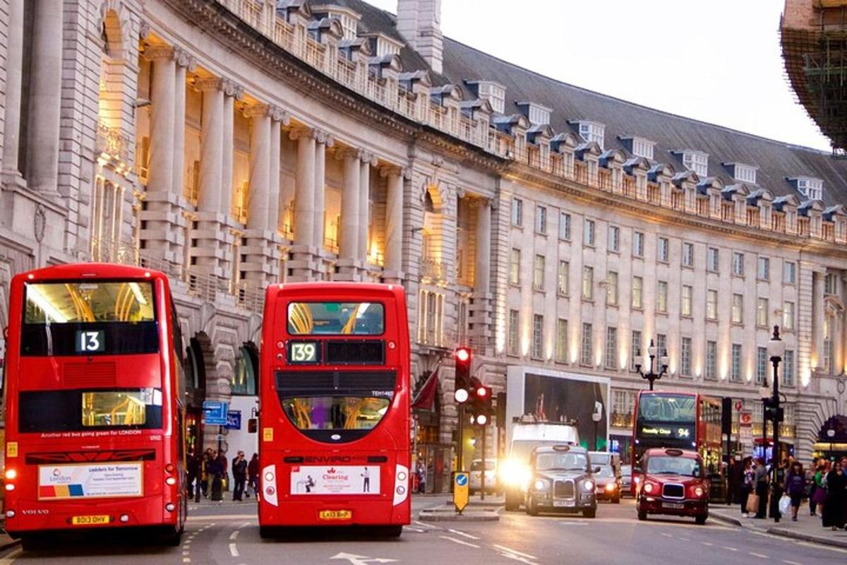 two red double decker buses driving down a city street