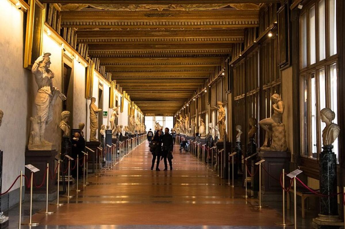 a hallway in a museum with statues on the walls