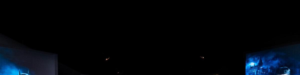 a dark room with a black sky and two buildings