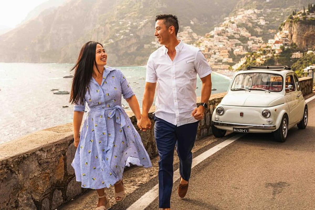 Un hombre y una mujer caminando por una calle al lado de un coche.