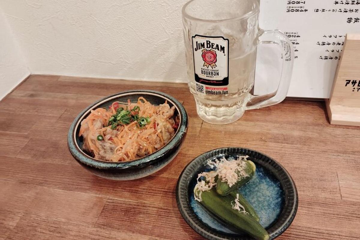 un tavolo con due ciotole di cibo e un bicchiere di birra