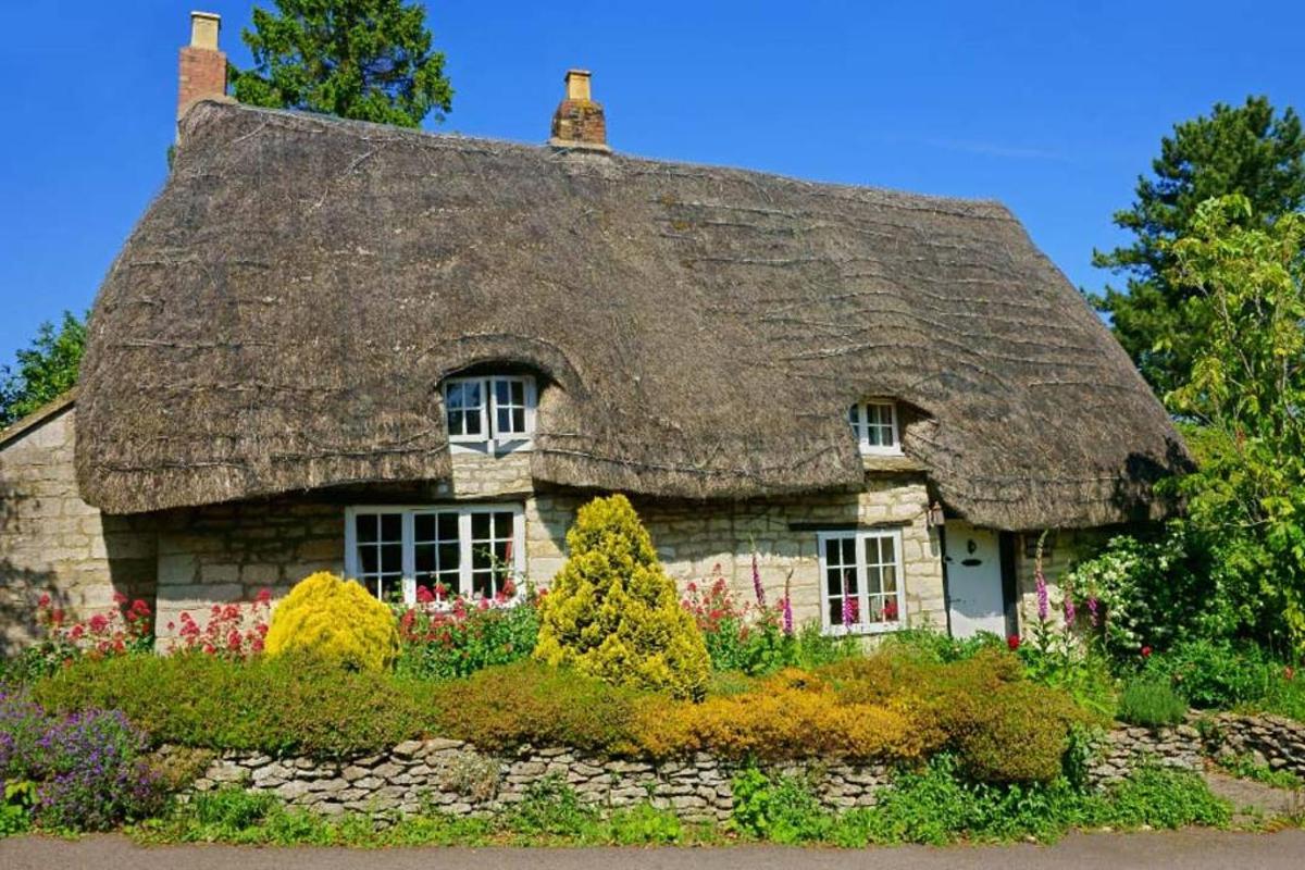 a small stone house with a thatched roof