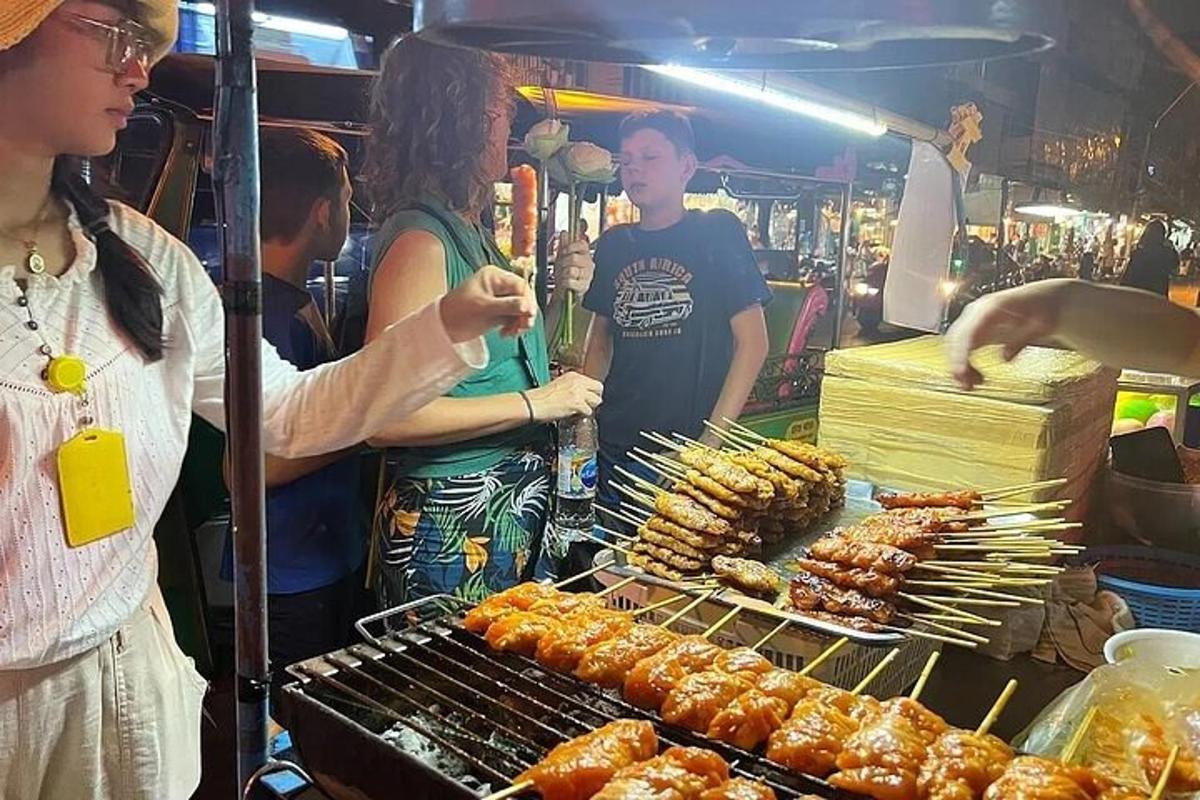 una persona cuinant menjar a la graella en un mercat