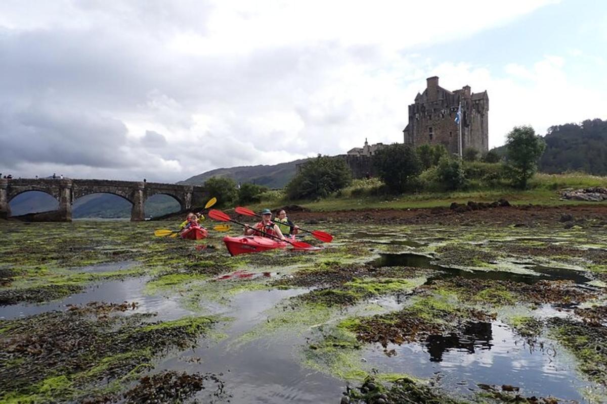 a group of people on kayaks in a river with a castle