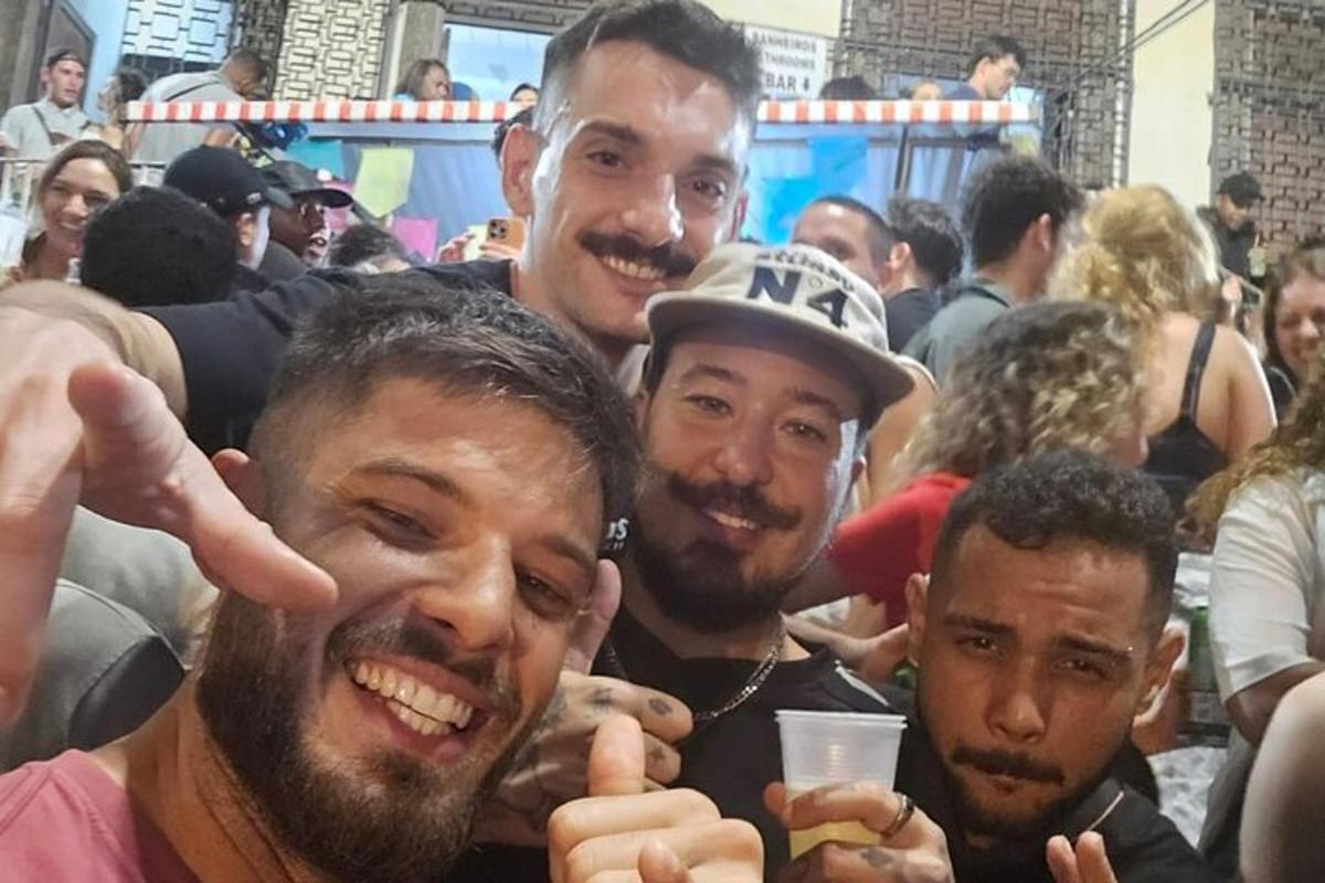 un gruppo di uomini che posano per una foto in mezzo alla folla