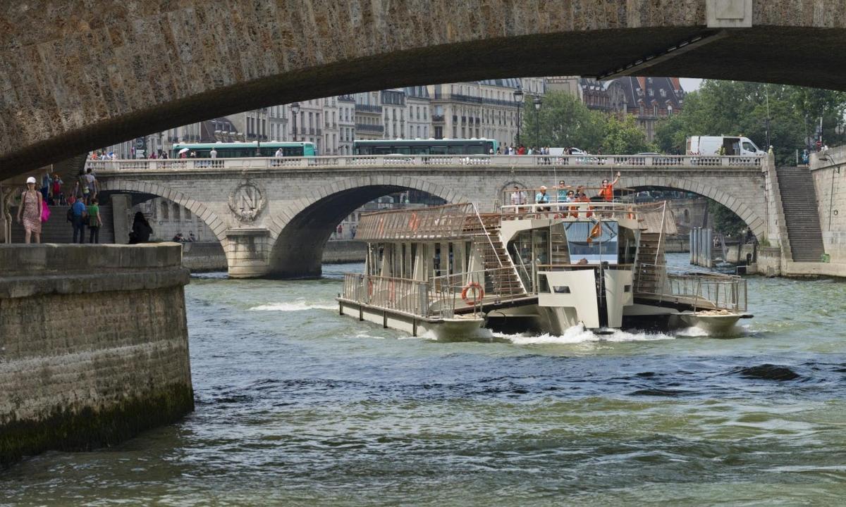 a boat traveling down a river under a bridge