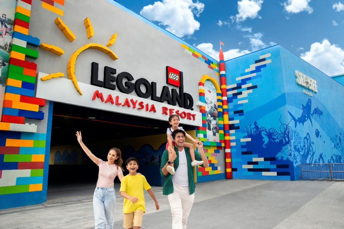 Rodina pózuje před malajským resortem Legoland