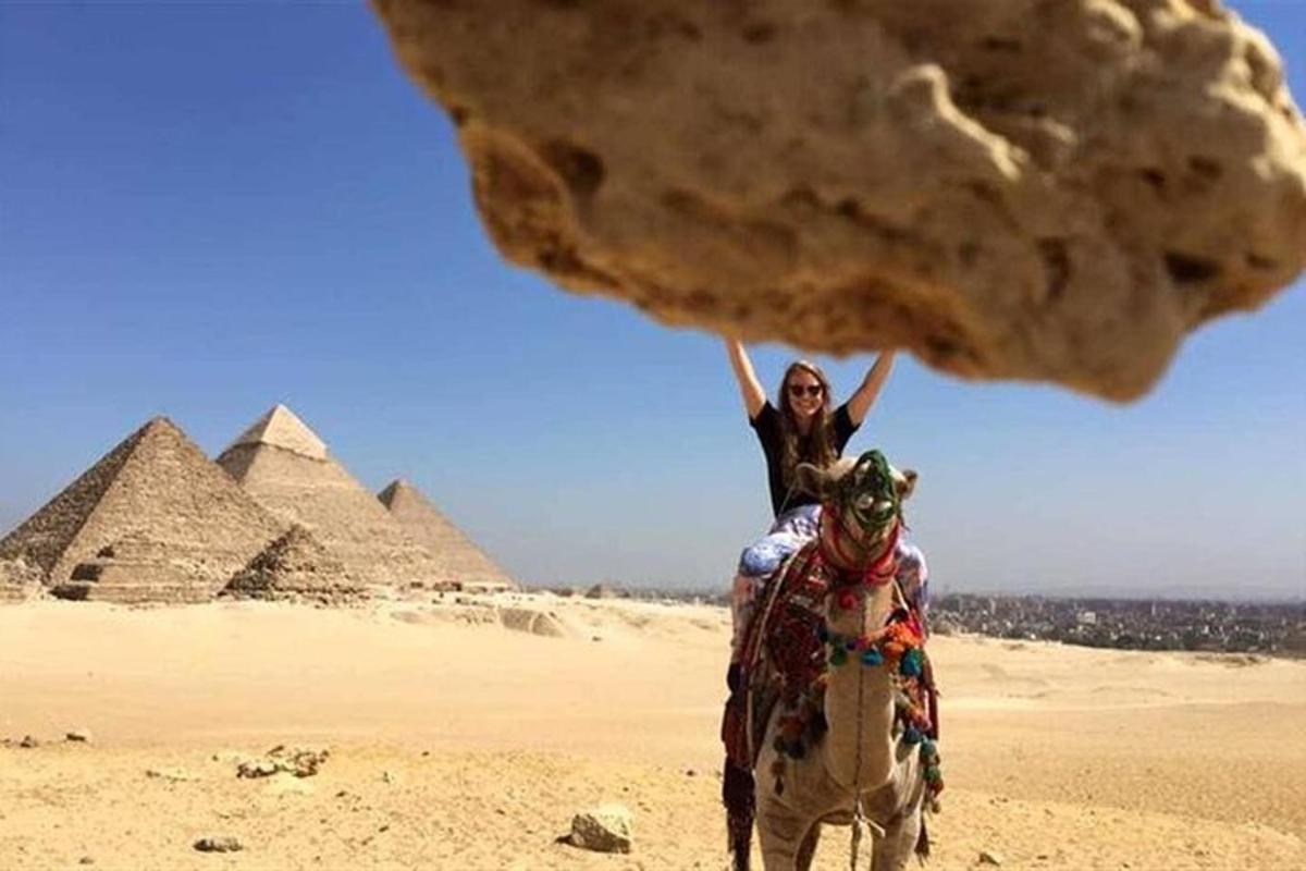 eine Frau reitet vor den Pyramiden