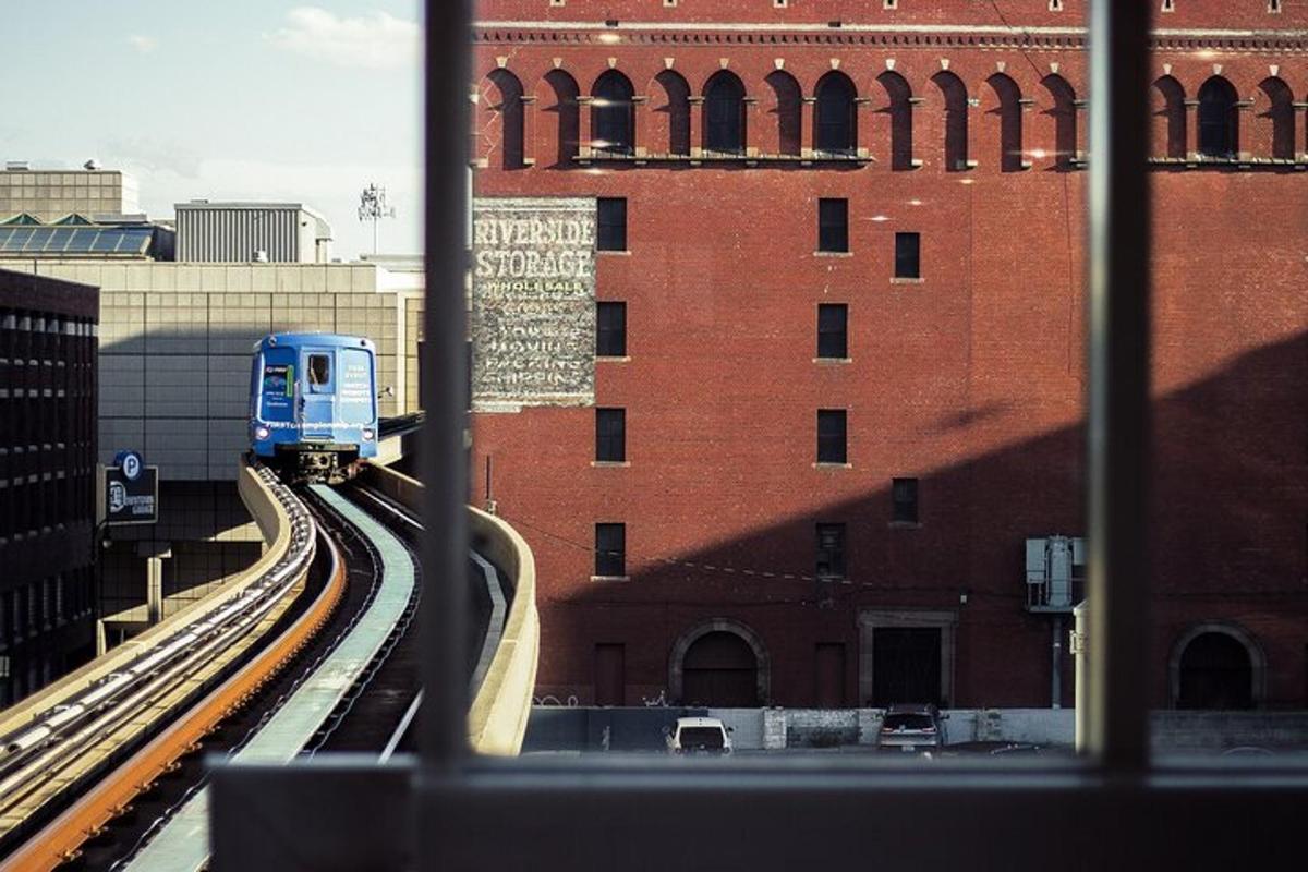 a blue train on tracks next to a brick building