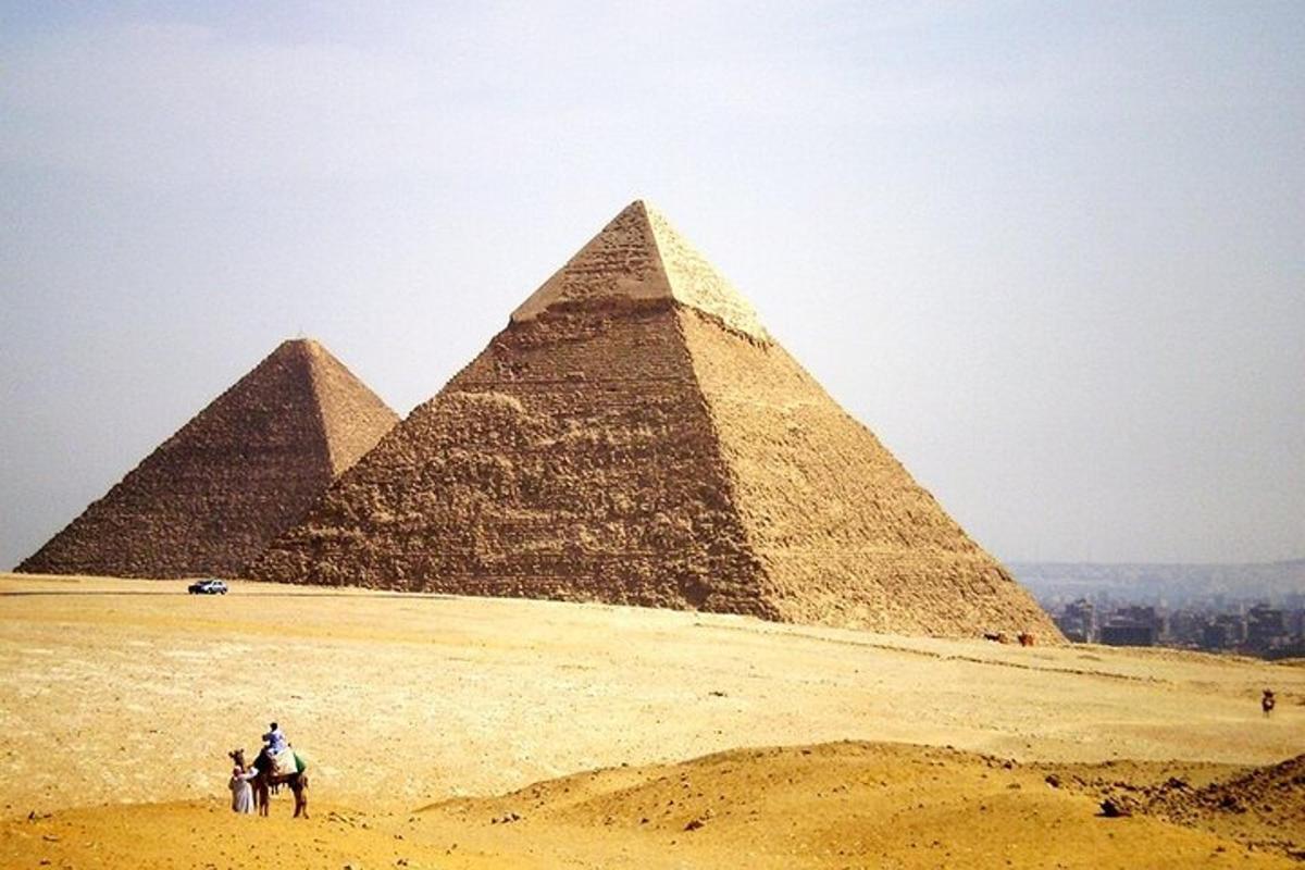 eine Gruppe von Pyramiden mit Menschen auf Pferden davor