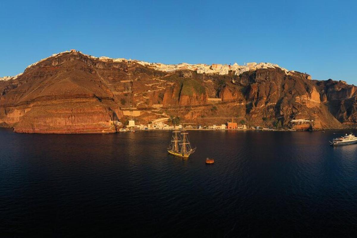 a boat in a body of water next to a mountain