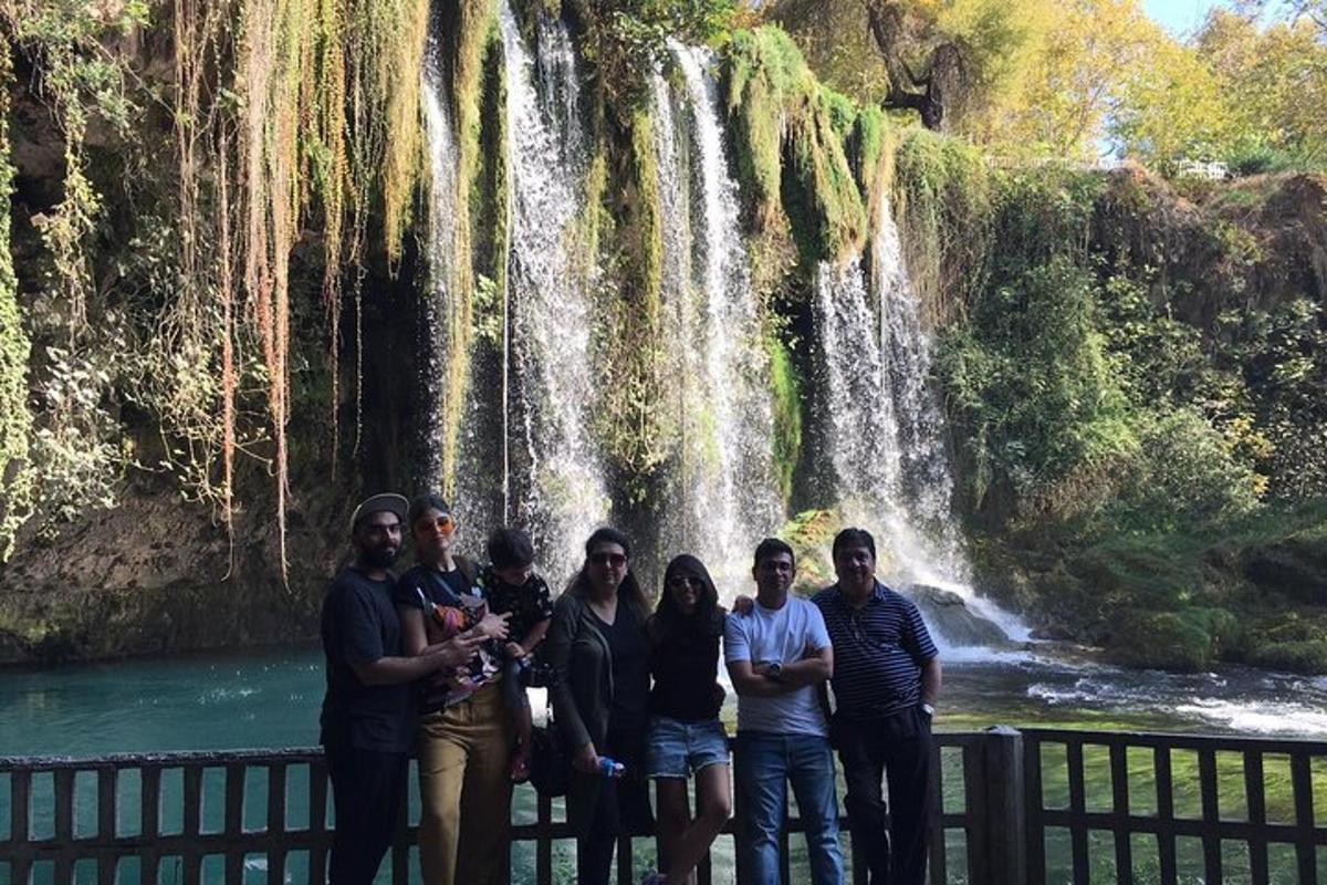 eine Gruppe von Menschen steht vor einem Wasserfall