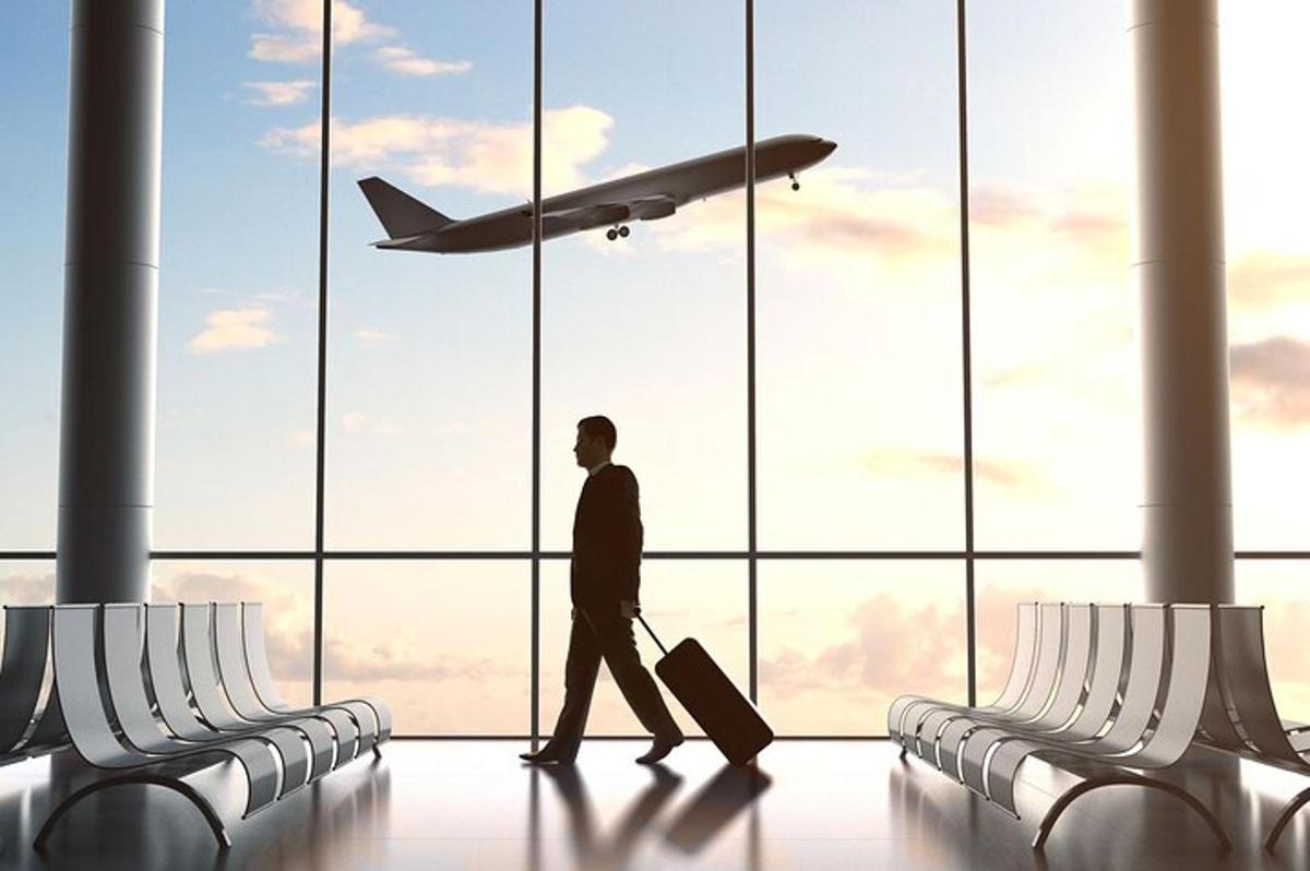 um homem caminhando por um aeroporto com um avião