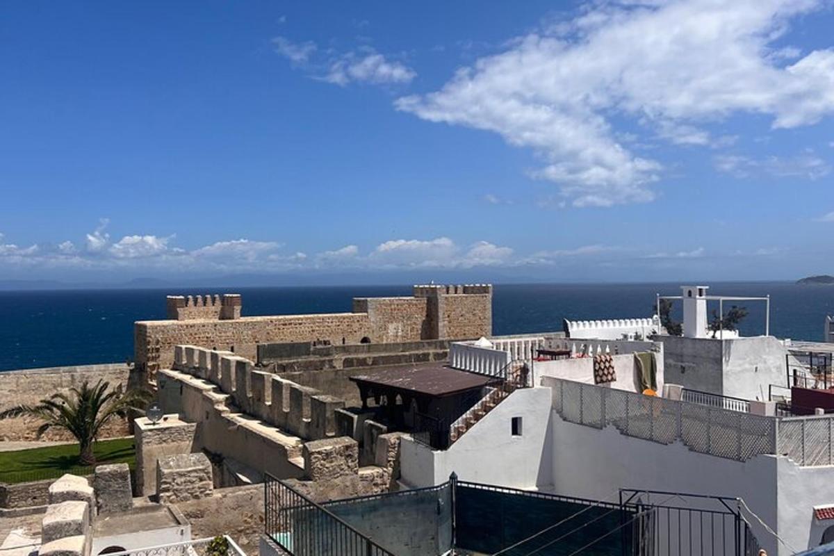an old building with the ocean in the background