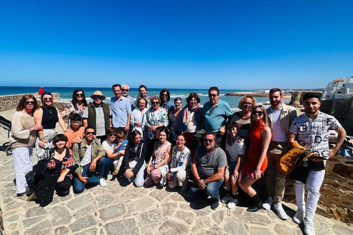 een groep mensen die poseren voor een foto op het strand