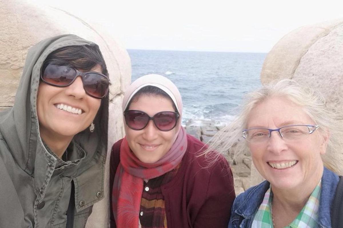 tre donne sono in piedi vicino all'oceano