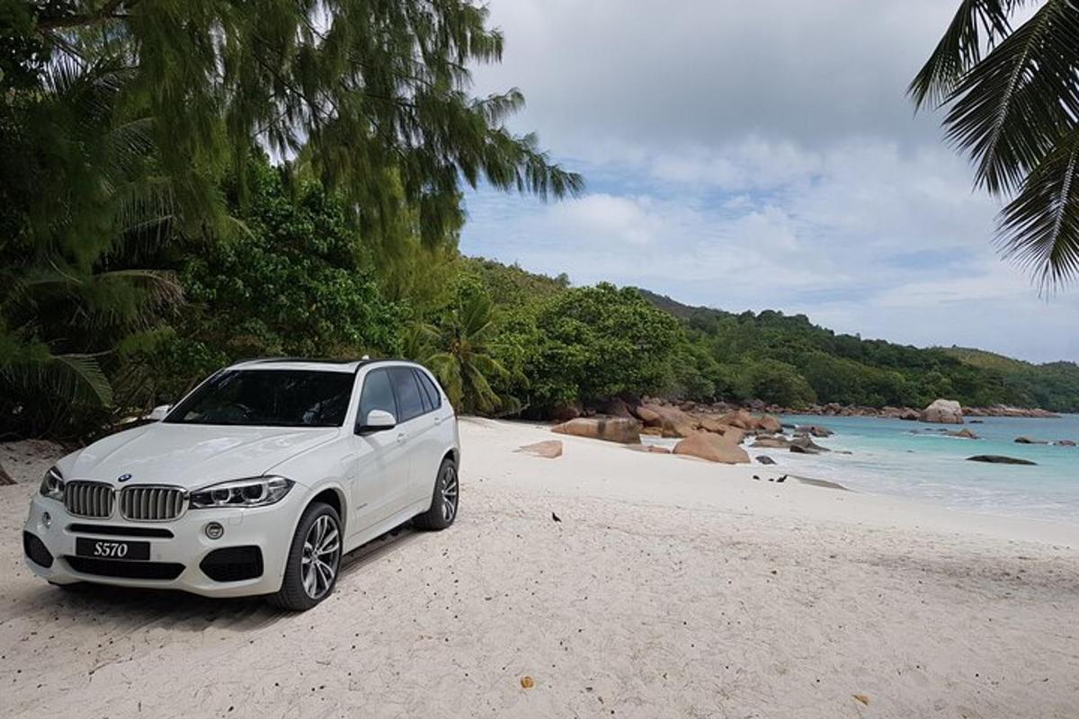 a white car parked on a beach near the ocean