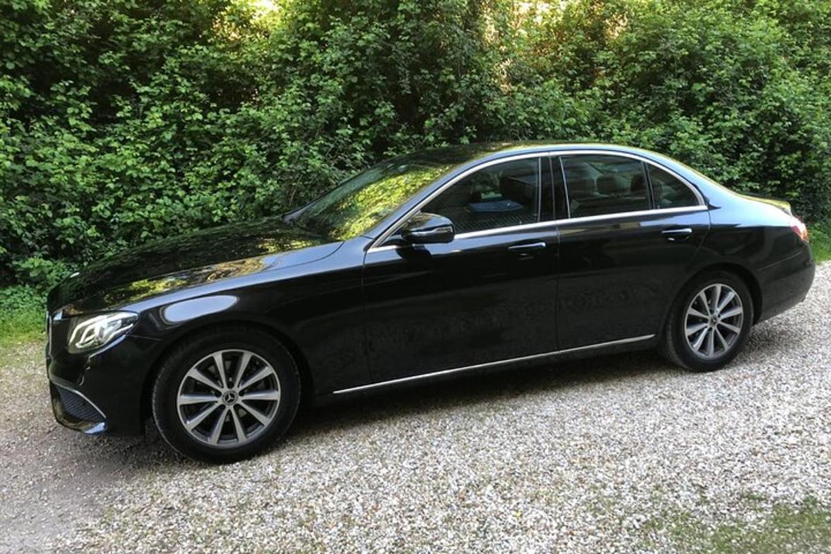 a black car parked in a gravel driveway